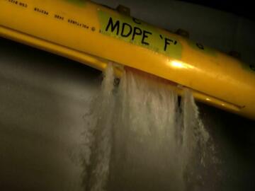 Flowing burst test of pipe showing a rupture failure event