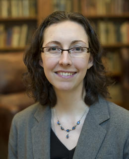 Professional headshot of Dr. Elizabeth Paris wearing black top and grey blazer and smiling at the camera.