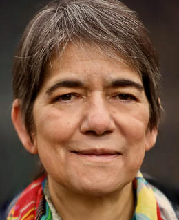 Head shot image of woman with dark hair and colourful scarf.