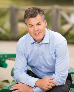 Sunny day, sitting, smiling with arms folded