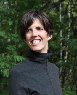 white woman with brown hair smiling with shoulders back