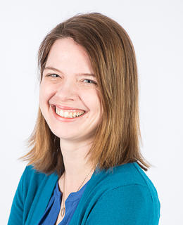 white woman with brown hair wearing a teal cardigan