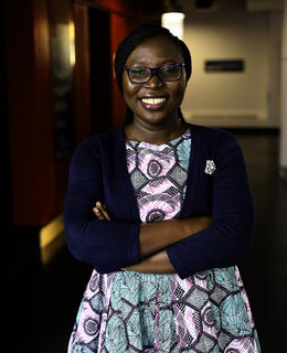 Motilola smiling with arms folded across her chest