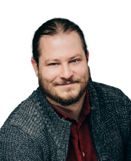Headshot. Caucasian male in a navy sweater and maroon shirt.
