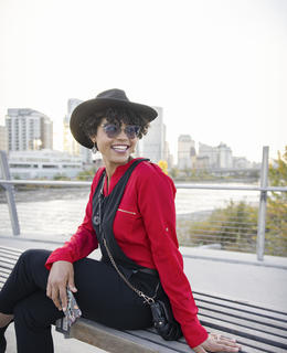 Amanda is shown sitting on a bench smiling as she looks over her shoulder.