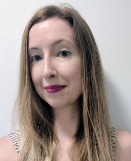 Caucasian woman with dark blonde hair, purple lipstick