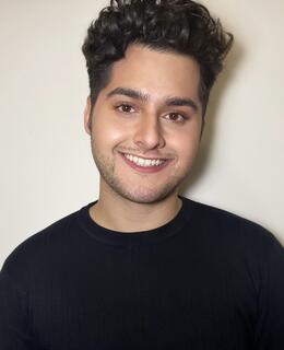 A headshot of a white man with dark brown hair