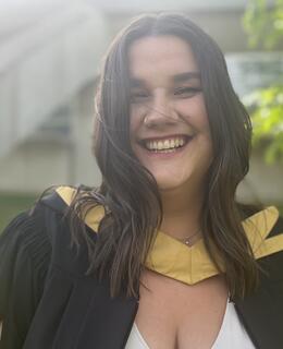 Hilary can be seen in graduation robes smiling 