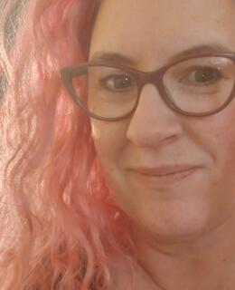 Woman with glasses and pink hair