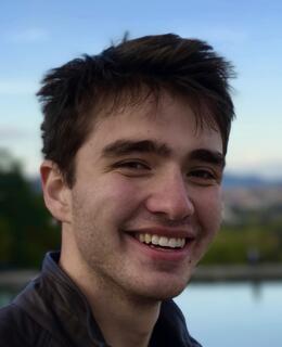 Maxim Vinogradov smiling in front of a lake.