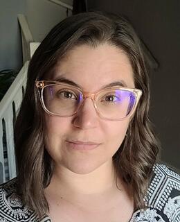 Picture of a white woman, medium length brown hair, glasses.