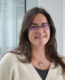 Picture of a woman smiling in front of a glass window