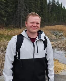 Myself standing next to a small creek within trees