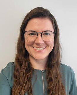 Headshot of Dr. Brittany Edgett from the shoulders up smiling in a green business casual top.