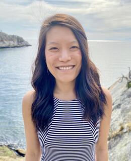 headshot of Sharon Hou from the torsal up smiling in front of scenic view