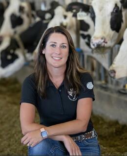 Photo of Dr. Betty-Jo Bradley in front of a row of Holstein cows