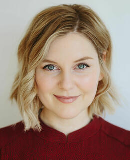 Photo of a woman with blonde hair in a red shirt.