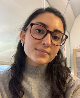 woman with long brown hair wearing a grey turtleneck