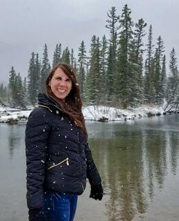Dr. Redick standing beside a river in Kananaskis, during a snowfall.