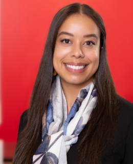 Taylor's headshot with a red background.