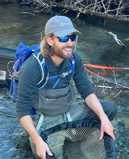 Assisting Tara Lepine with fish sampling on Smith-Dorrien Creek.