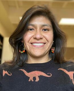 Headshot of Lilia in her office, she is using a cool dino jumper