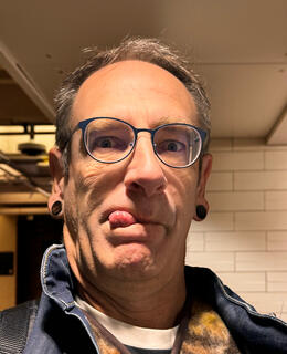 An image of me with blue glasses and my tongue sticking out like a complete idiot