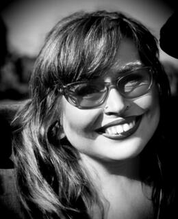 A black-and-white photo of Dr. Rain Prud'homme Cranford. They have medium-length hair and glasses.