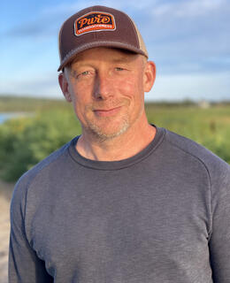 Middle age man in baseball cap, background sky