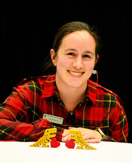 Image of Kate with two flexi-rexi dinos on a white table.