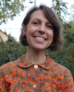 A photo of a white woman with short brown hair smiling 