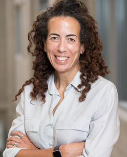 Woman with brown hair, smiling at camera