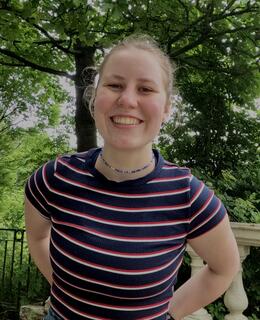 Jelka in a striped t-shirt, outdoors.