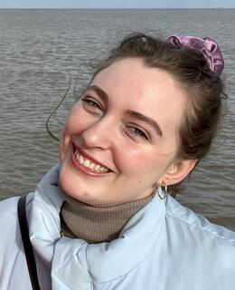 Portrait of Mara Zschommler outside in front of the ocean