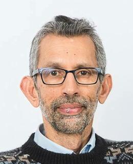 Man wearing glasses and black and cream sweater