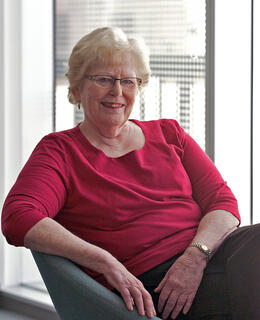 Dr. Elizabeth Jameson sitting in a chair wearing a red shirt
