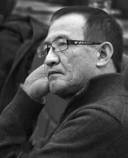 A black-and-white photo of Dr. Shaobo Xie. He has short hair, glasses, and wears a dark-coloured sweater.