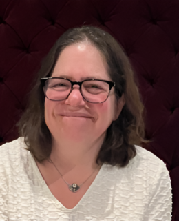 Image of Dr. Faye Halpern. She has shoulder-length brown hair, glasses, and is wearing a white sweater. 