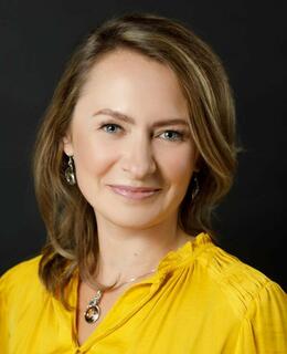 The image of a smiling woman in a yellow blouse