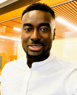 A black man with dark hair, with white shirt