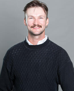 smiling man in black sweater