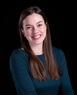 Grace has brown hair and is smiling 