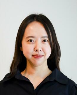 Headshot of Heun Lee. She has dark brown hair, wearing a black shirt.
