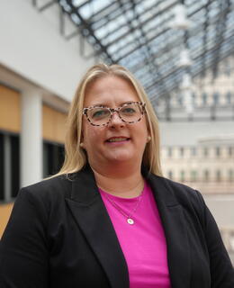 Photo of Lindsey wearing a pink shirt and black jacket