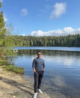 Sayan standing infront of a lake.