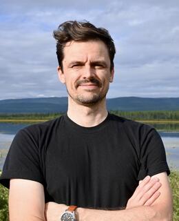 Photo of David Janzen in front of a lake in Yukon, Canada.